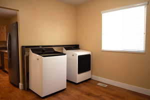 Laundry room with dark wood-style flooring and washing machine and dryer