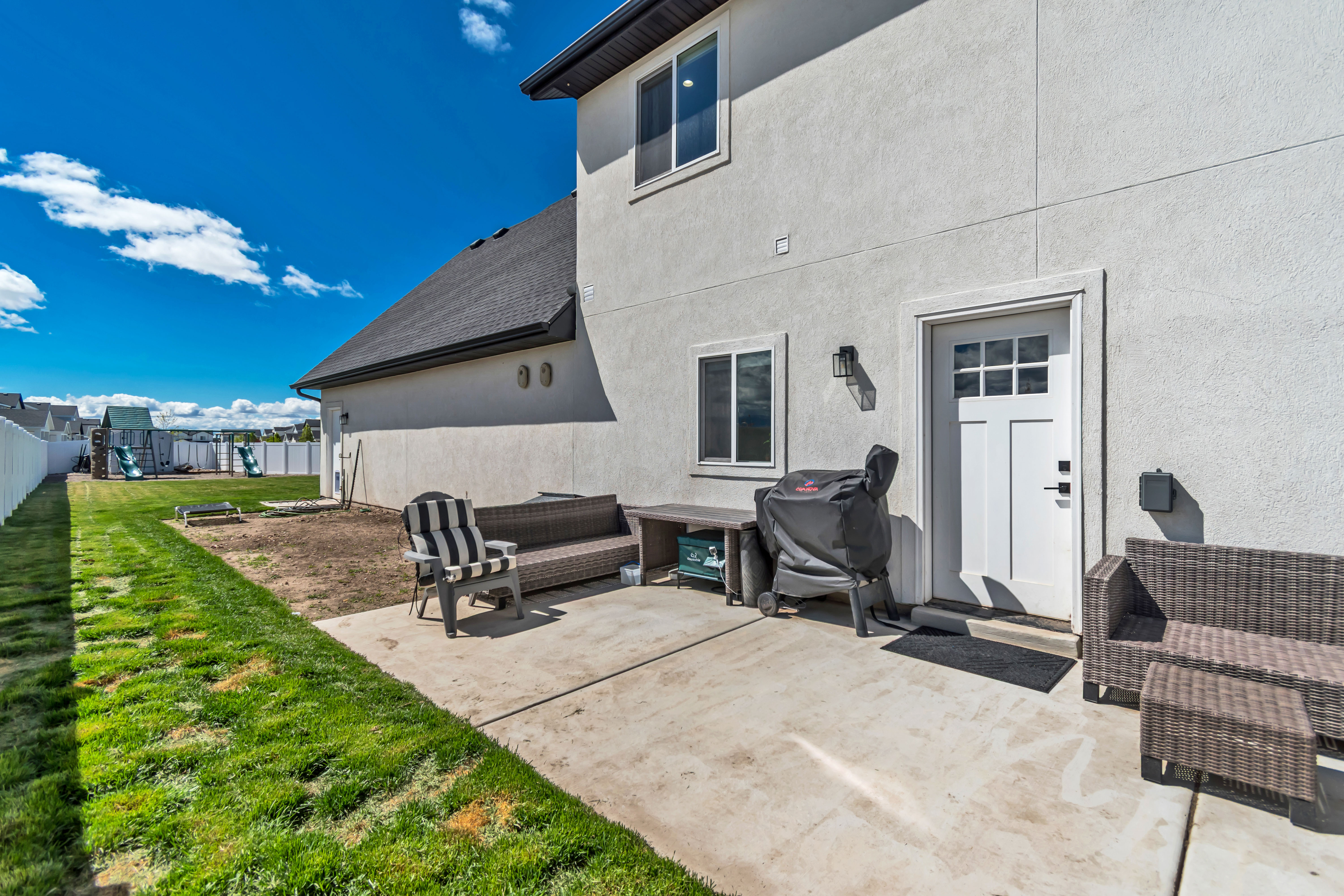 Rear view of property with a patio and vegetable garden plot.