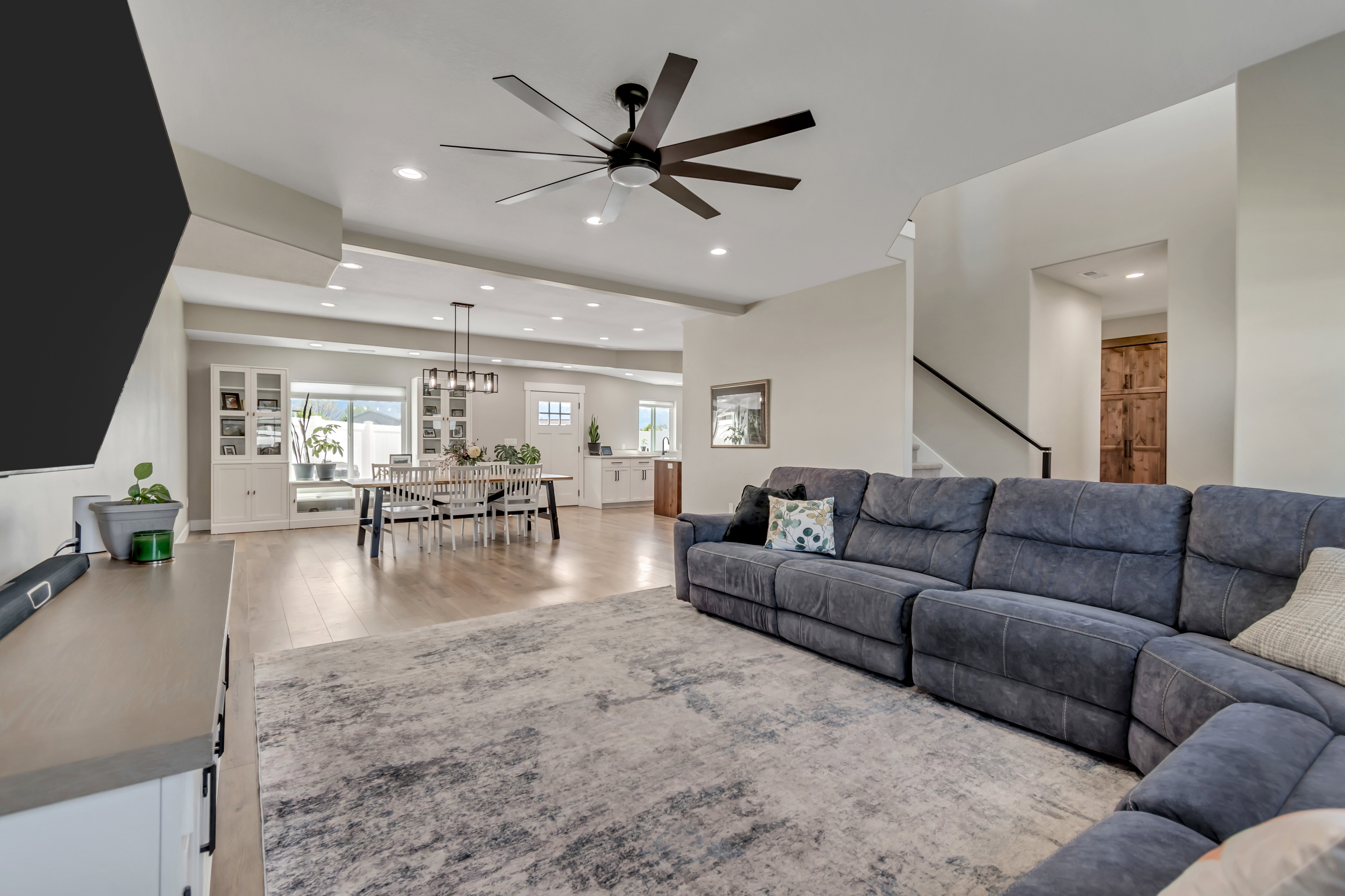 Living area with light wood-type flooring, a ceiling fan, and recessed lighting