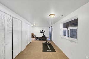 Workout room with light carpet and baseboards