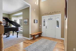 Entryway featuring light wood-style flooring and ornamental molding
