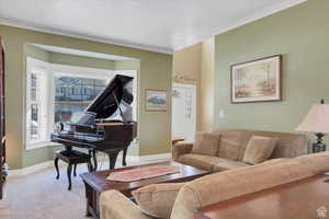 Living area with carpet floors and ornamental molding