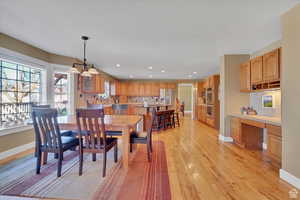 Dining room with built in desk, light wood finished floors, and recessed lighting