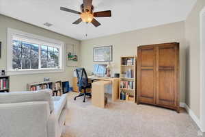 Office area with ceiling fan and light carpet