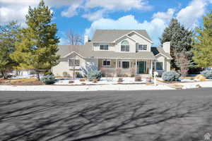 View of front of property with a chimney and covered porch
