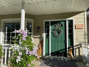 View of exterior entry featuring covered porch