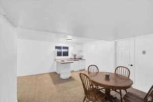 Dining area featuring light colored carpet and baseboards