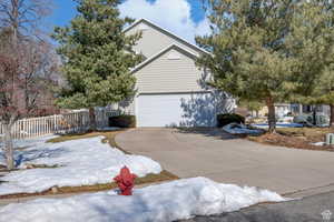 View of property exterior with concrete driveway and an attached garage