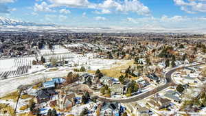 Snowy aerial view with a mountain view and a residential view