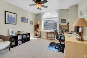 Office space featuring light carpet and a ceiling fan