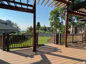Deck with a fenced backyard and a pergola