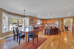 Dining space with light wood-style floors and a chandelier