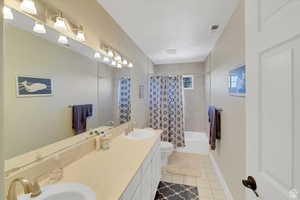 Bathroom featuring double vanity, light tile patterned floors, and shower / bathtub combination with curtain