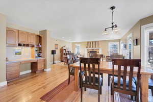 Dining area with light wood-type flooring, a fireplace, and built in study area