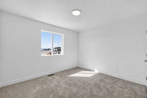 Unfurnished room featuring baseboards and carpet
