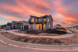Contemporary house featuring a residential view, concrete driveway, an attached garage, and stone siding