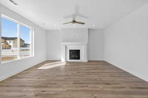 Unfurnished living room with ceiling fan, light wood-style flooring, a fireplace, and recessed lighting