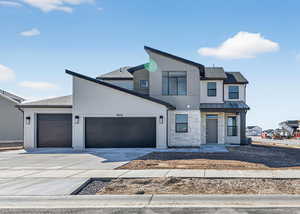 Contemporary house with a garage, concrete driveway, stone siding, and a shingled roof