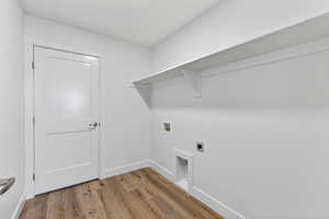 Laundry room featuring hookup for a washing machine, light wood-type flooring, and electric dryer hookup