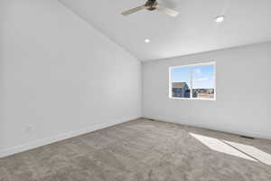 Carpeted spare room with lofted ceiling, ceiling fan, and recessed lighting