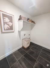 Utility space featuring dark rectangular floor tiles and white wall paint