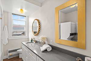 Full bath with vanity, radiator heating unit, and dark wood-style floors