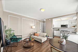 Living room featuring dark wood-type flooring and ornamental molding