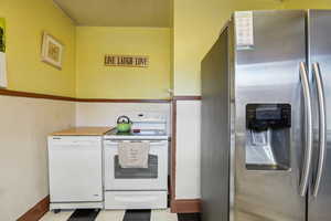 Kitchen featuring white appliances and baseboards