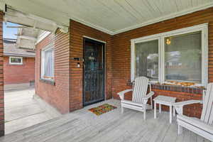 Doorway to property featuring brick siding