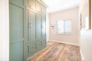 Mudroom featuring light wood finished floors and baseboards