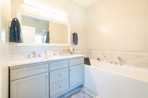 Bathroom featuring double vanity and a bath