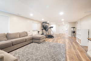 Living room with light wood-style flooring and recessed lighting