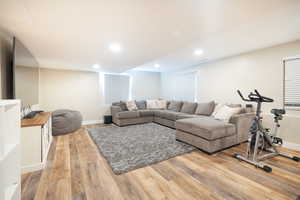 Living area with light wood finished floors and recessed lighting