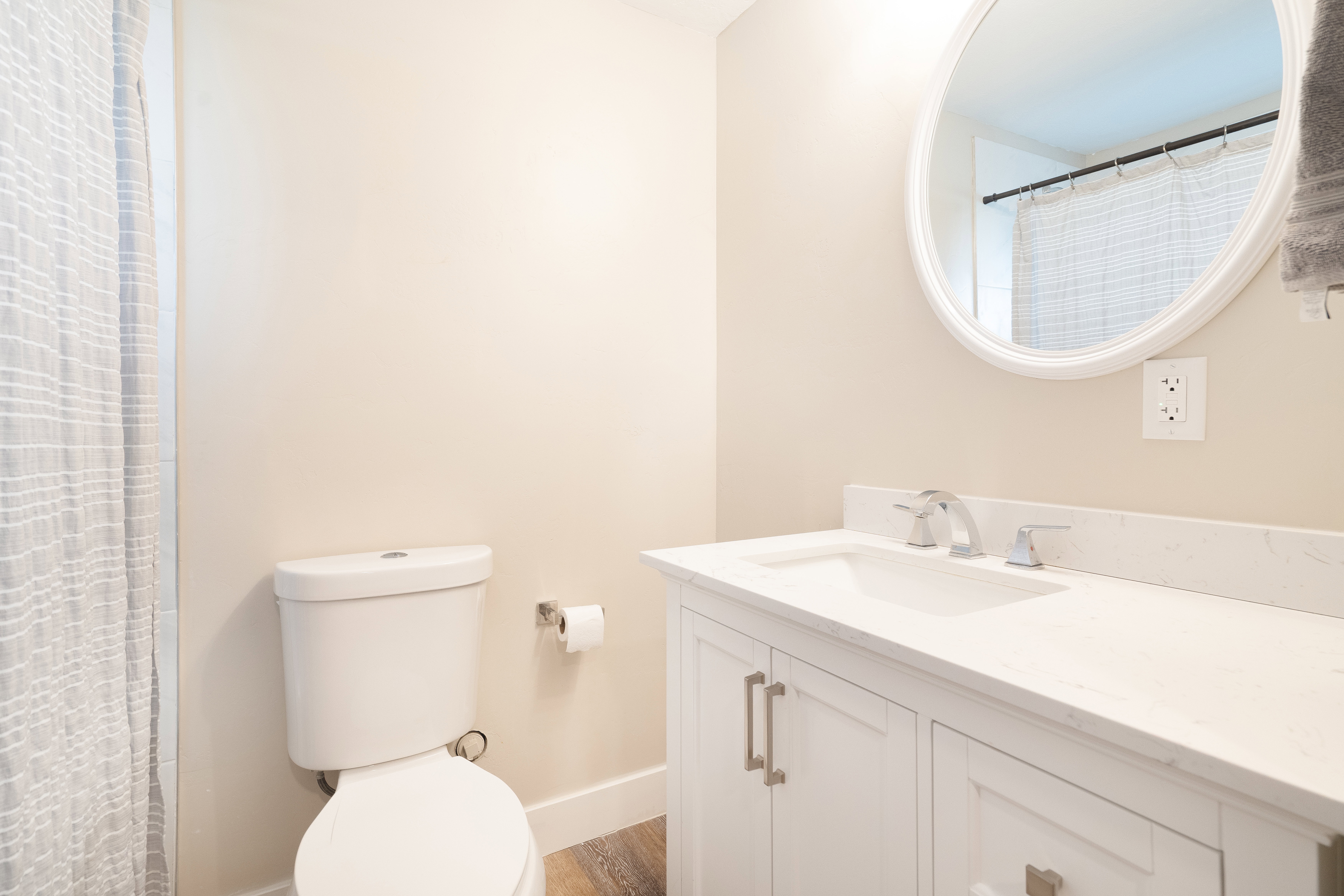 Full bath featuring vanity, curtained shower, and dark wood-style floors