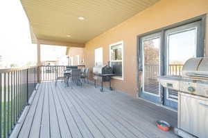 Wooden deck with outdoor dining space and grilling area
