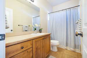 Full bathroom featuring vanity, a shower with shower curtain, and light tile patterned floors