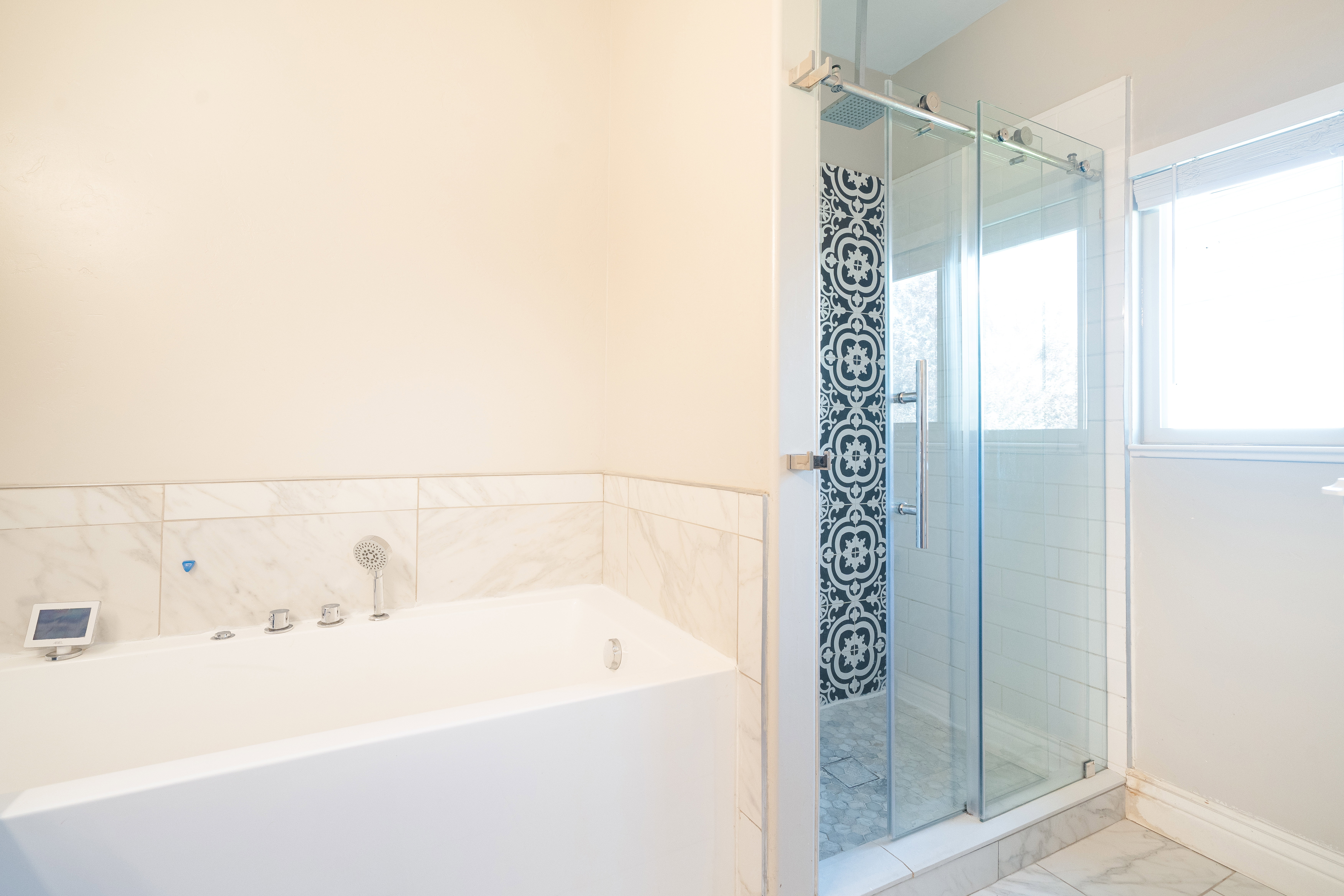 Bathroom featuring a stall shower, a bath, and marble look tiles