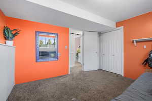 Bedroom featuring carpet, a textured ceiling, and a closet