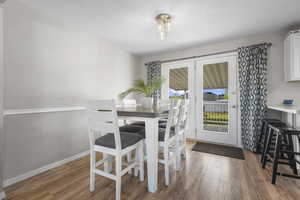 Dining room featuring dark wood-style flooring and a textured ceiling