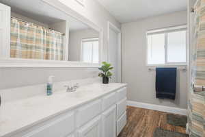 Bathroom featuring vanity, a shower with shower curtain, and dark wood-style floors