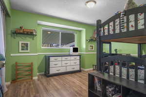 Bedroom featuring dark wood-style flooring and a textured ceiling