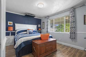 Bedroom with dark wood finished floors and a textured ceiling