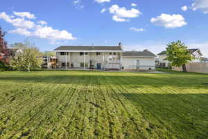 Rear view of property featuring a chimney, a patio, and a wooden deck