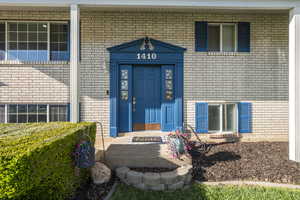 View of exterior entry featuring brick siding