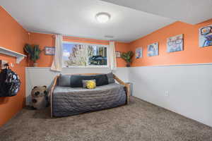 Bedroom with carpet and a textured ceiling