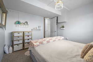 Carpeted bedroom featuring suspended lighting