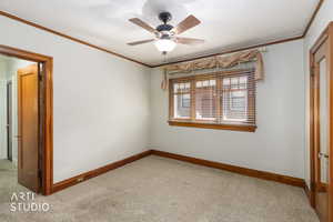 Unfurnished bedroom featuring crown molding, light colored carpet, a ceiling fan, and a closet