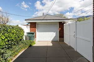Detached garage with concrete driveway and a gate