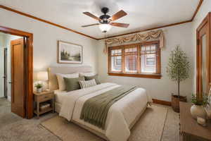 Virtually staged bedroom featuring ornamental molding, ceiling fan, and carpet floors