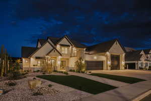View of front facade with stone siding, stucco siding, and concrete driveway